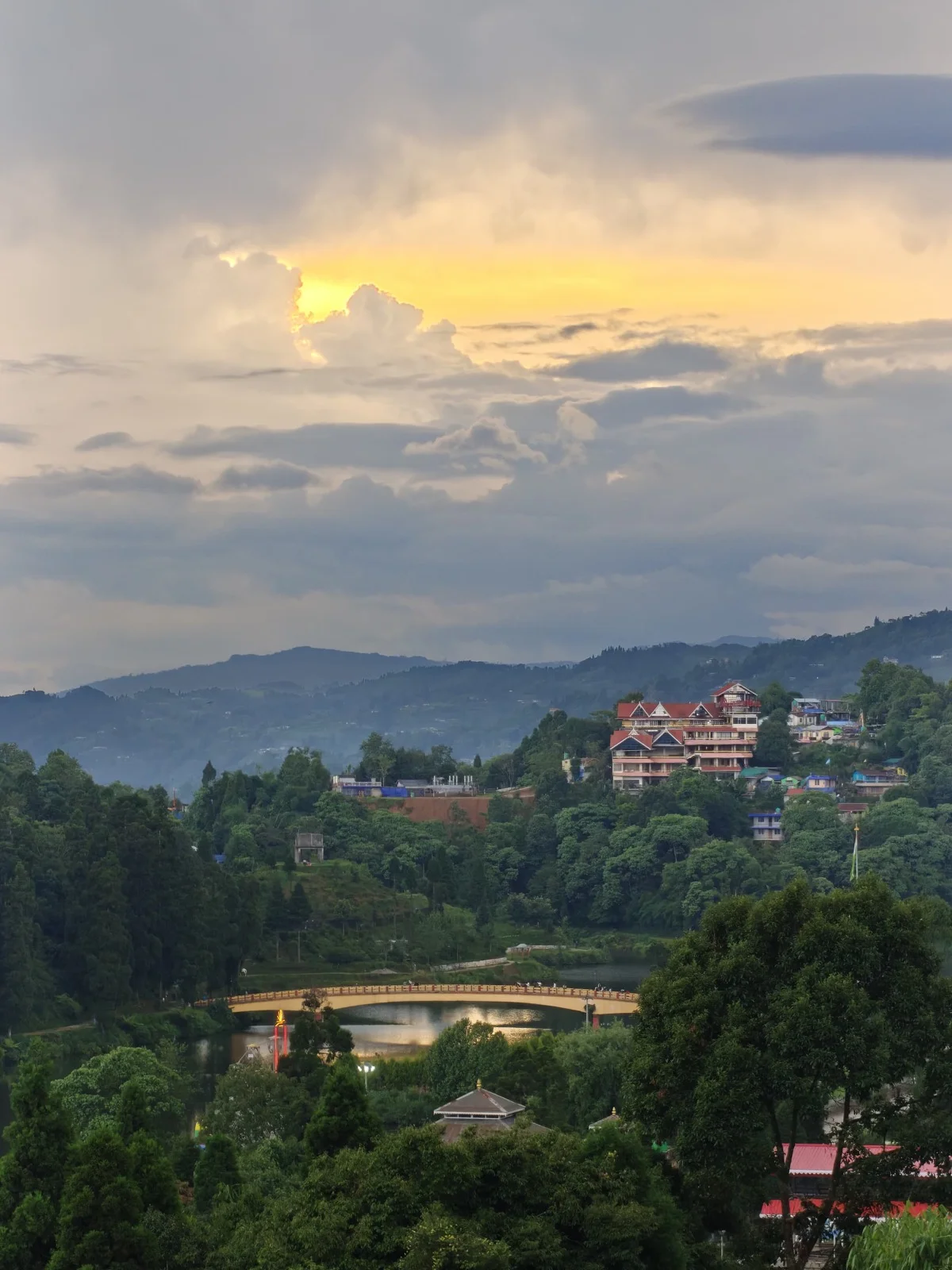 Sunset over Mirik lake and the Darjeeling hills, with the footbridge and hillside homes